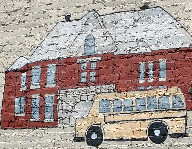 Close up of a mural with a painting of a school bus and school